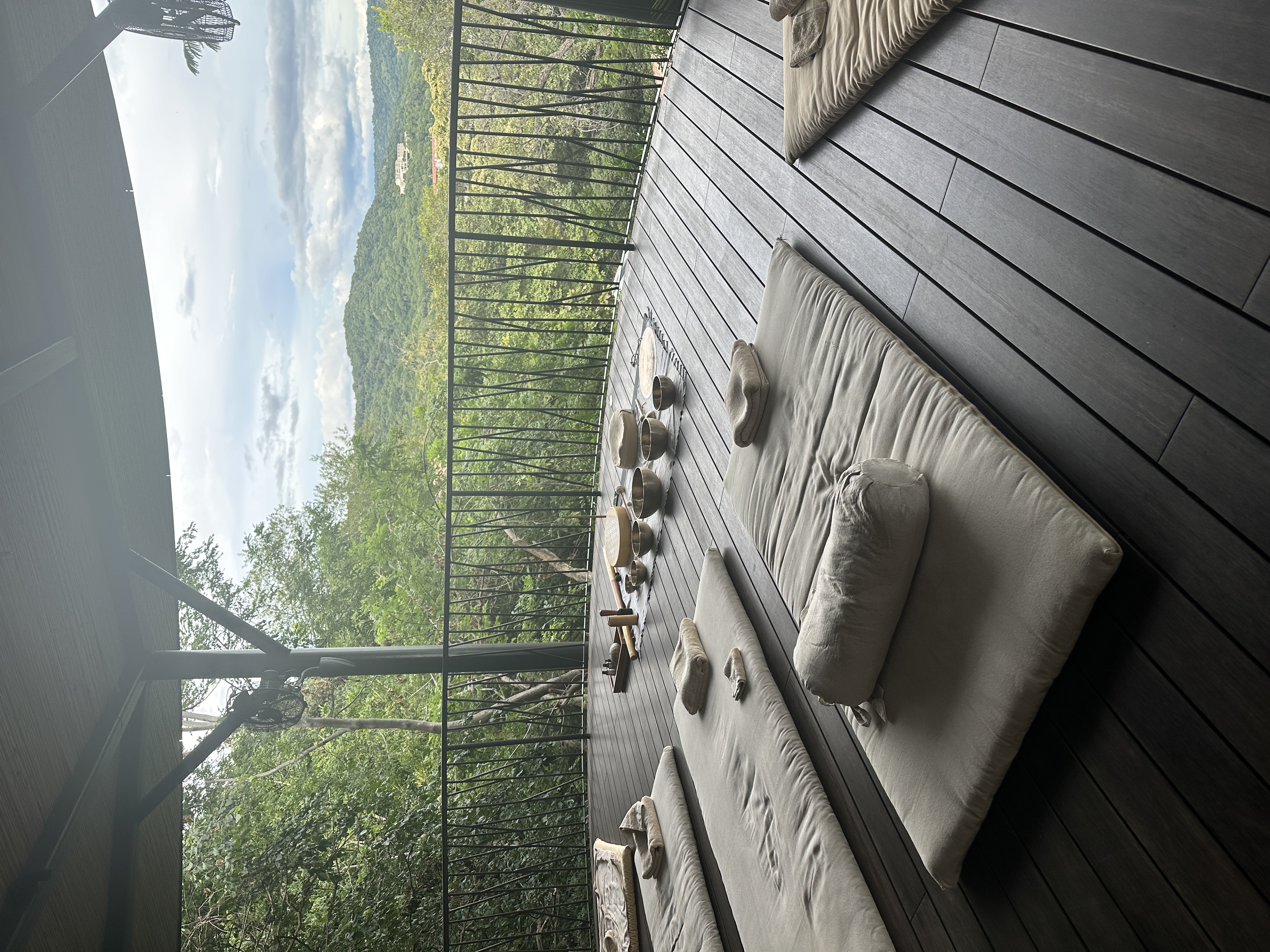 Open-air wellness pavilion with singing bowls overlooking the jungle hills